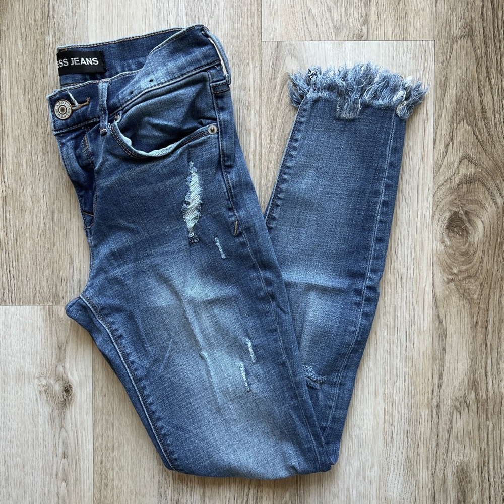Mid rise distressed fringe skinny jeans